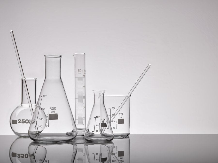 Verrerie de laboratoire disposée sur une surface réfléchissante