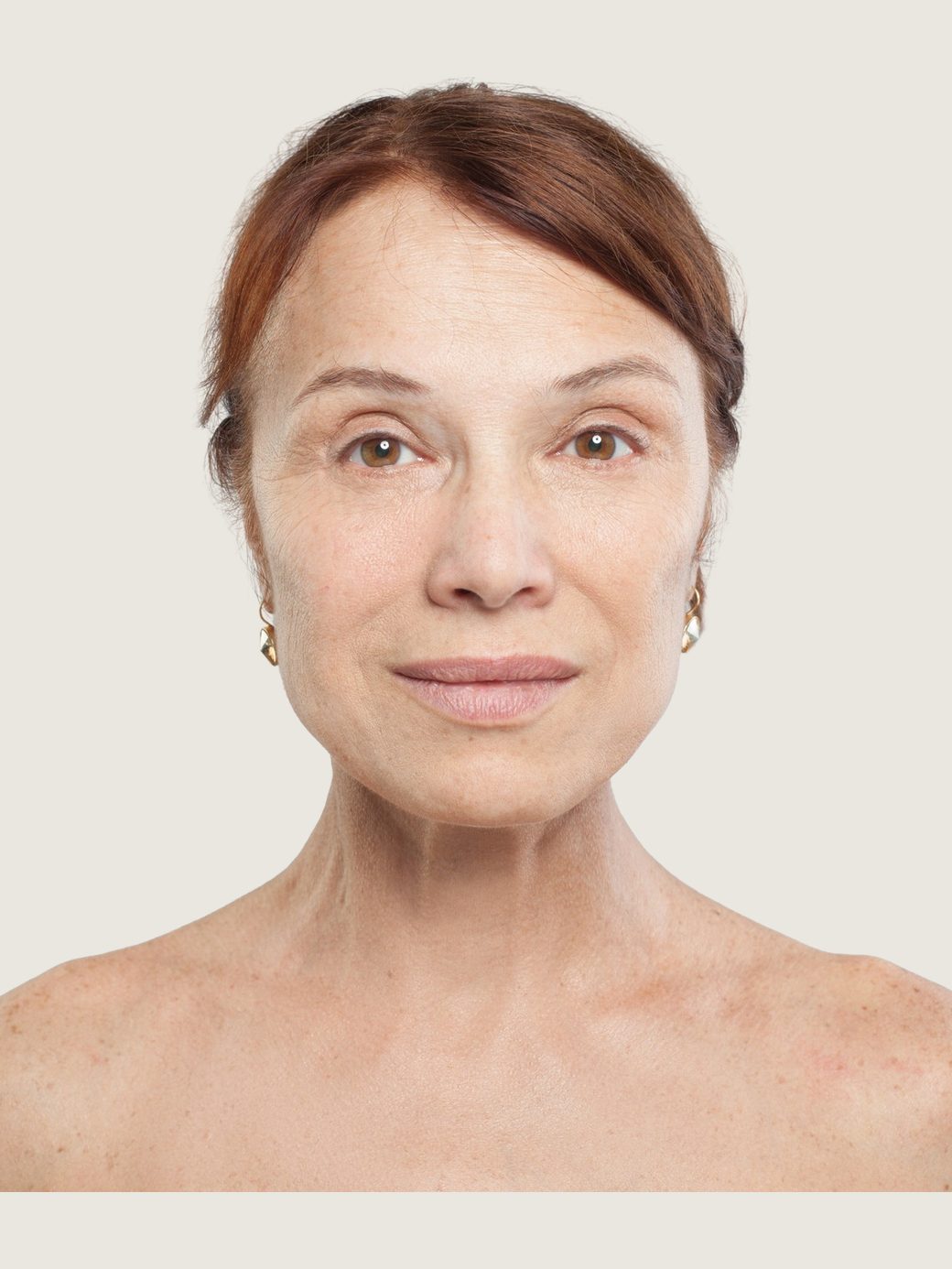 Retrato de una mujer de unos sesenta años, hombros descubiertos, luz de estudio neutra